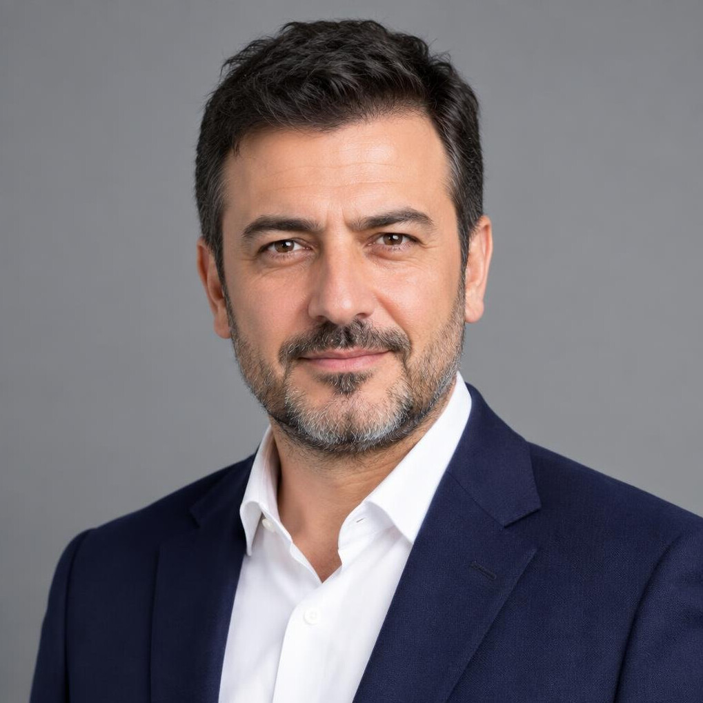 Portrait of a Turkish man in his 40s wearing a blazer, professional headshot